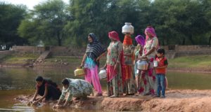 Women in Rajasthan filling water from a pond deepened by Ambuja Cement Foundation