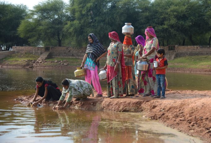 Women in Rajasthan filling water from a pond deepened by Ambuja Cement Foundation